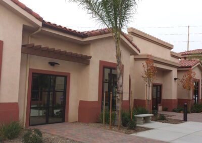 A tan building with a palm tree in front of it.