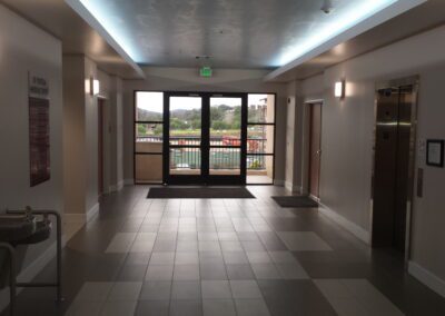 A hallway with a door leading to an elevator.