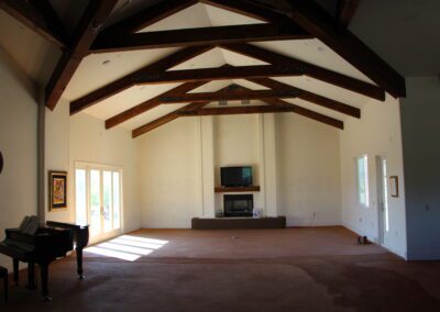 A living room with a piano and a fireplace.