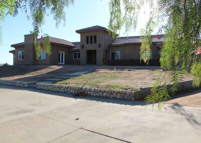 A house with a driveway and a tree in front of it.